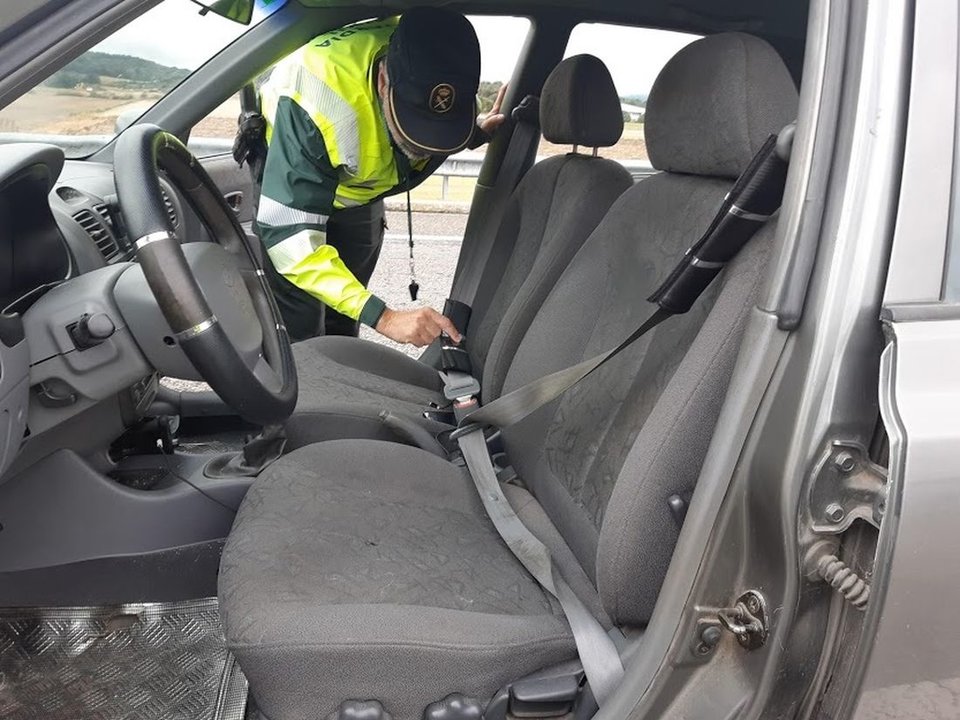 Un agente inspecciona el enganche del cinturón de seguridad que instaló un conductor en su vehículo.