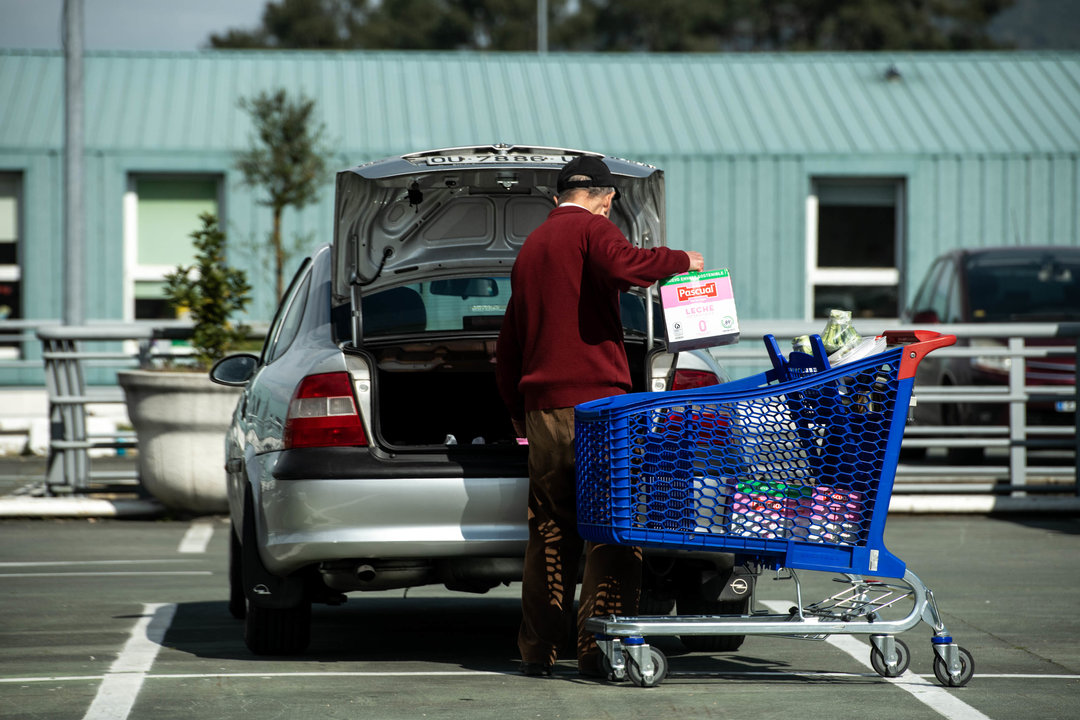 Un cliente introduce en su vehículo la mercancía adquirida en un supermercado.