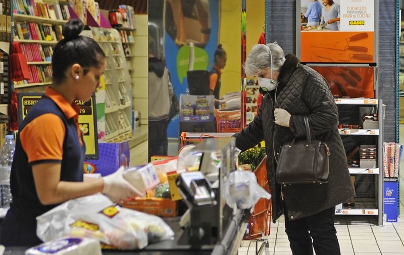 Una mujer con mascarilla hace ayer la compra en un supermercado de la ciudad (MARTIÑO PINAL).
