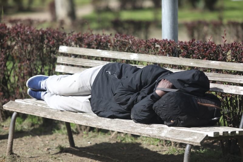 Un hombre duerme en un banco del parque de Os Remedios, la mañana del domingo (JOSÉ PAZ).