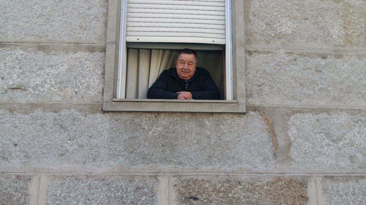 José Vázquez Nóvoa fuma un pitillito en la ventana de su casa.
