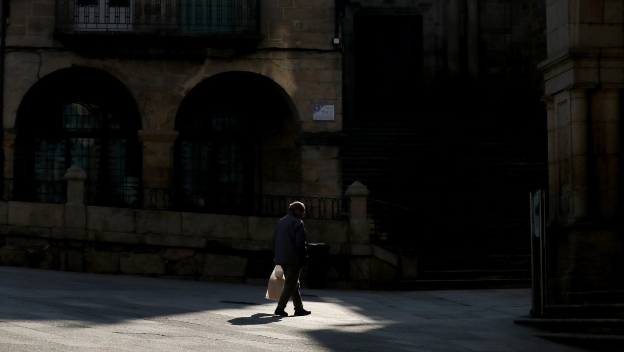 Plaza Mayor por la mañana, un transeúnte camina con el periódico bajo una gran sombra (JOSÉ PAZ).