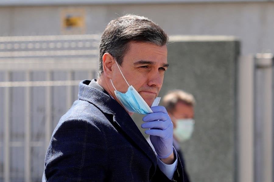 El presidente del gobierno, Pedro Sánchez (c), se protege con mascarilla y guantes a su llegada, este viernes, a las instalaciones de la empresa Hersill, en Móstoles. (Foto: EFE)