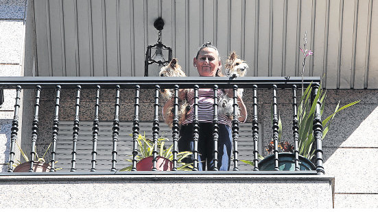 María en el balcón de su casa con sus perritos Teo y Lúa.