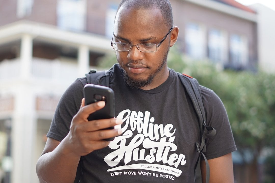 Un hombre consulta su teléfono móvil mientras pasea por la calle. (Foto: Unsplash)