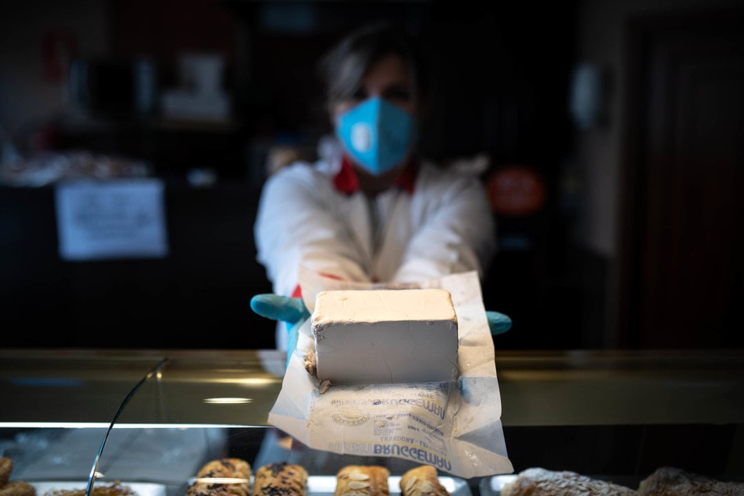 OURENSE (PASTELERÍA SABUCEDO). 07/04/2020. OURENSE. Una empleada de la panadería Sabucedo muestra una porción de levadura fresca en su paquete, un producto que se está vendiendo mucho por el confinamiento de los vecinos. FOTO: ÓSCAR PINAL