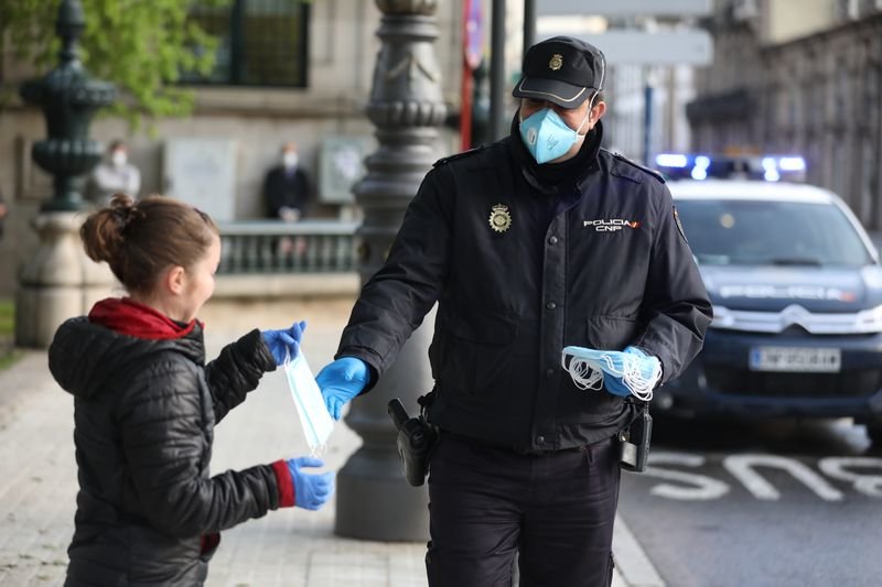Un Policía entrega mascarillas a una vecina de la ciudad (JOSÉ PAZ).