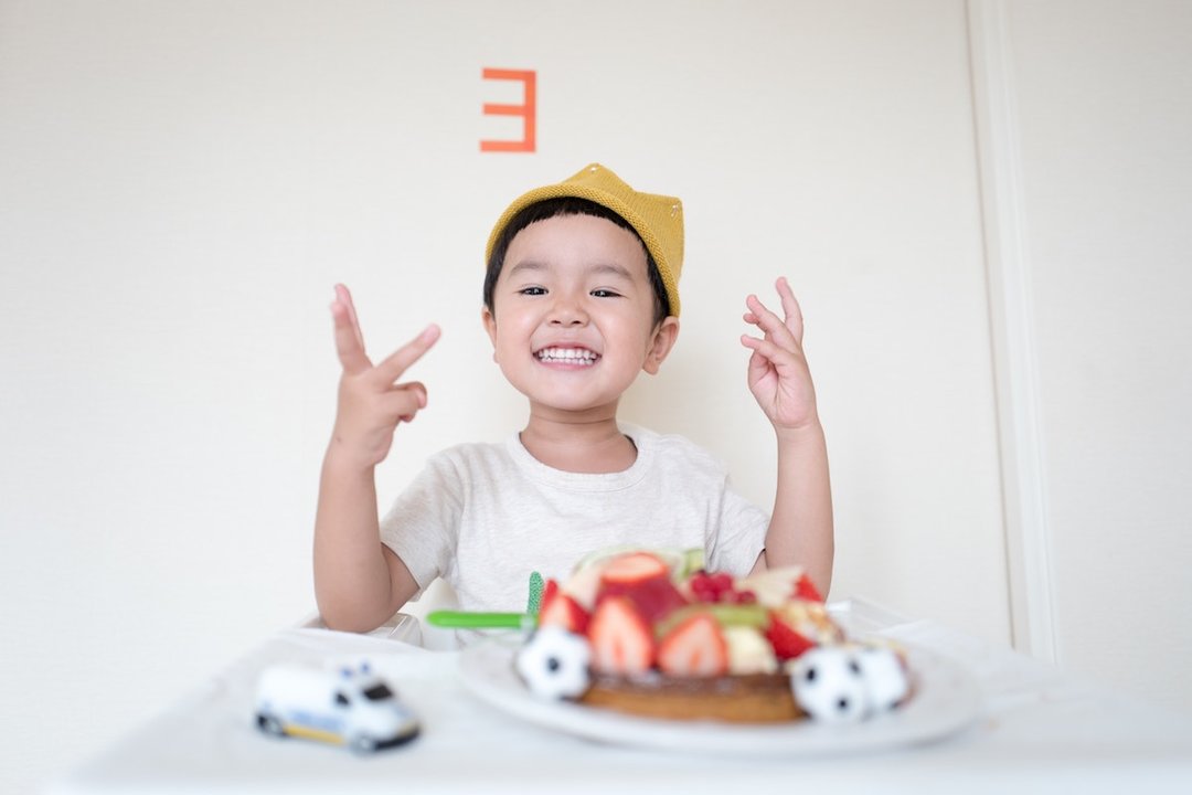 Un niño sonríe ante un pastel. (Foto: Unsplash)