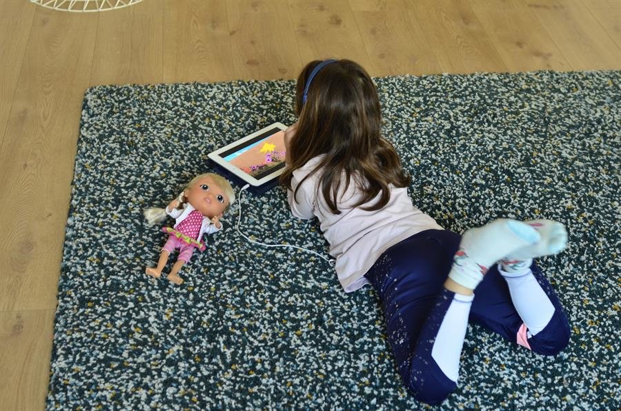 Una niña mira una tablet en casa (EFE).