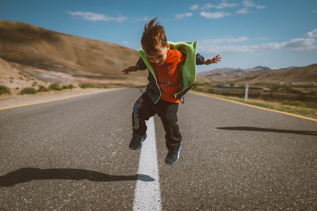 Un niño salta en la carretera. (Foto: Unsplash)