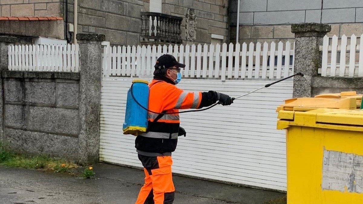 Un voluntario de Protección Civil desinfectando en la calle.