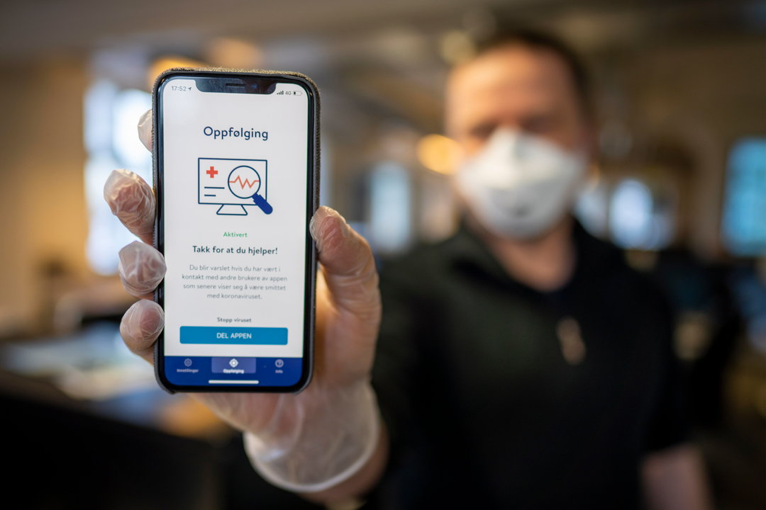 Un hombre muestra la aplicación móvil puesta en marcha en Noruega para seguir la pandemia. HEIKO JUNGE