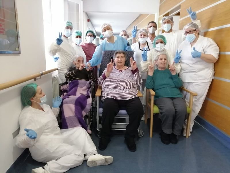 Mari Carmen Rodríguez, sentada con manta lila, con usuarios y trabajadores de la residencia Divino Maestro.