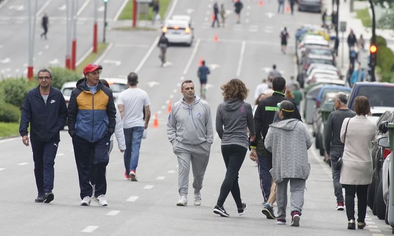 En Vigo, el alcalde, Abel Caballero, peatonaliza 22 calles cada tarde para los paseos, que en domingos y días festivos pasan a ser 70. En la imagen, vigueses caminan ayer por el medio de la avenida de Castelao.  (JVLANDÍN).
