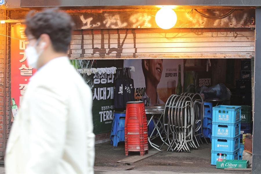 Un hombre pasa por delante de un bar en Sinchon, Seúl, Corea del Sur.