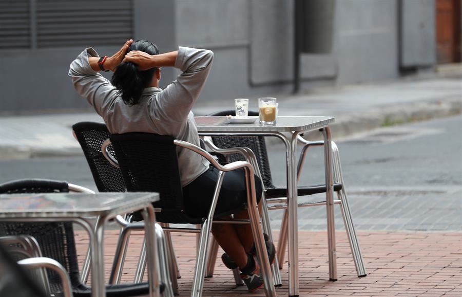 Una mujer sentada en una terraza (EFE).