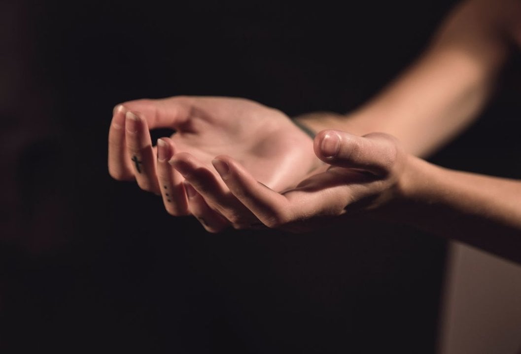 Una joven reza mostrando las palmas de sus manos. (Foto: Unsplash)