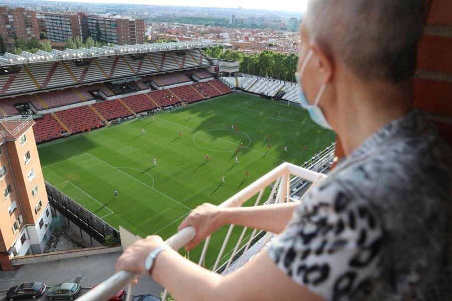 Un espectador observa el partido desde el balcón de su casa (EFE).