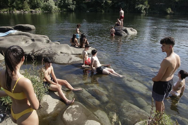 Jóvenes disfrutan ayer del agua del río Miño, en la zona del Puente Romano (MIGUEL ÁNGEL).