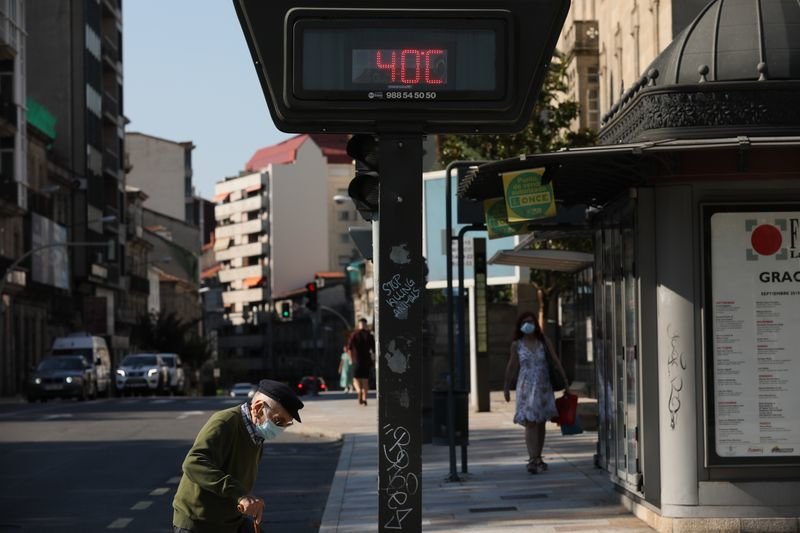 Viandantes cruzan junto al termómetro instalado en la Alameda, que llegó a marcar 40 grados a primera hora de la tarde (JOSÉ PAZ).