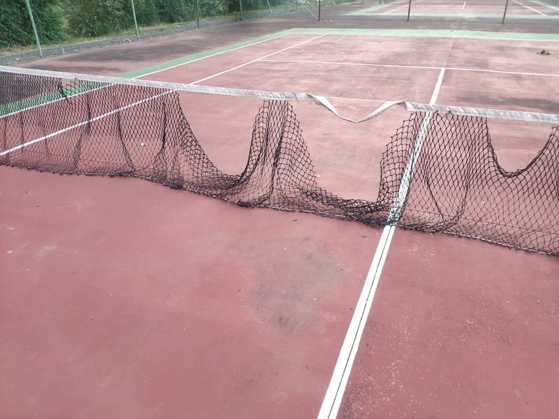 Imagen que ofrece una pista de tenis del recinto de las piscinas municipales.