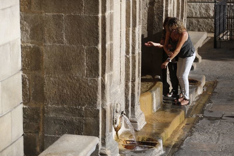 Dos turistas prueban el agua termal de As Burgas ayer por la tarde (XESÚS FARIÑAS).