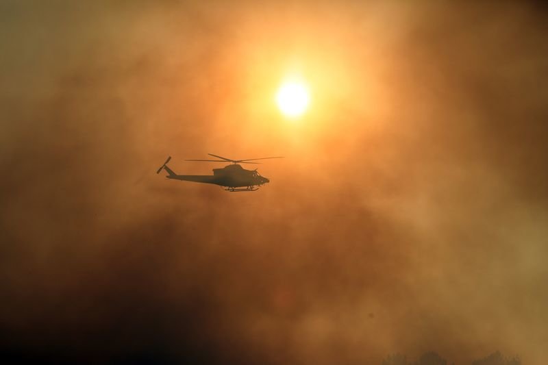 Un helicóptero esparce agua entre la densa humareda que generó el incendio (JOSÉ PAZ).
