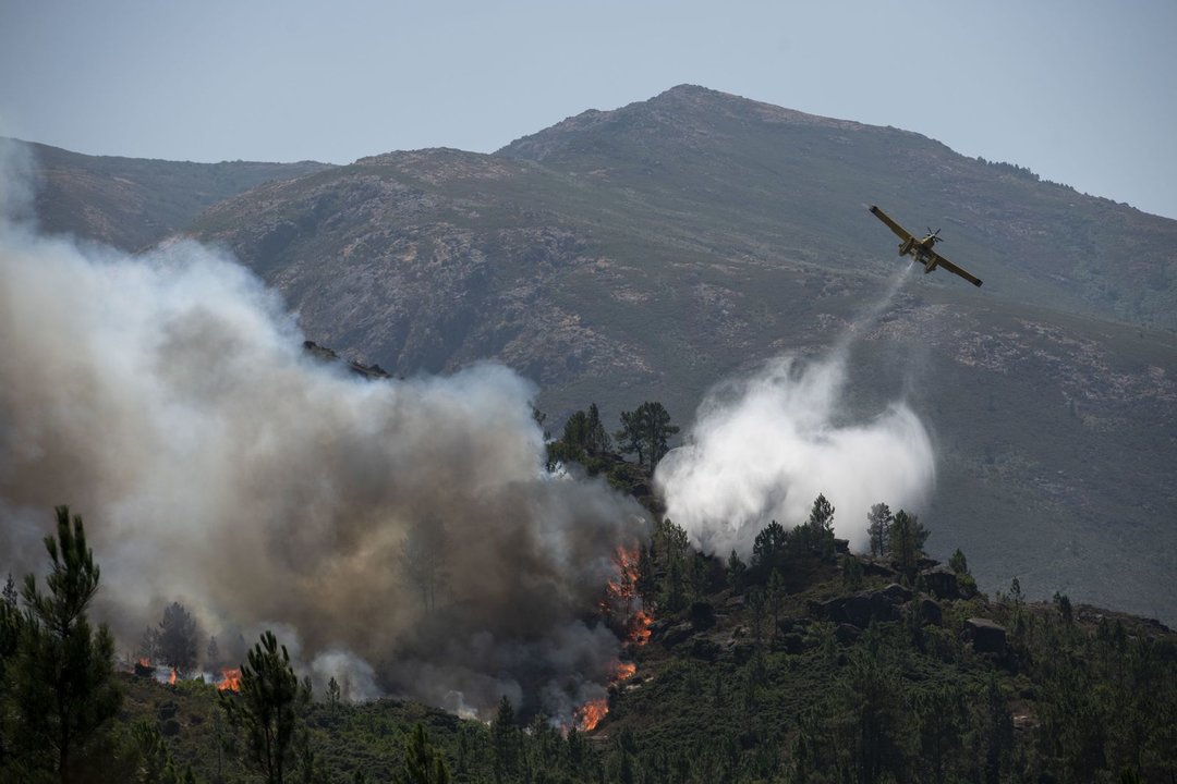 Uno de los aviones descarga agua sobre las llamas en el incendio de Lobios (ÓSCAR PINAL).