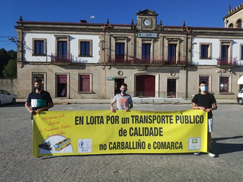Miembros de la Plataforma en Defensa del Transporte Público despliegan una pancarta.
