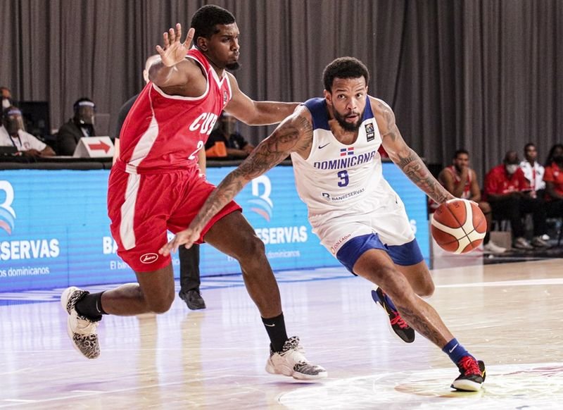 Adonys Henríquez supera la defensa de Yoanki Mensia (FIBA).