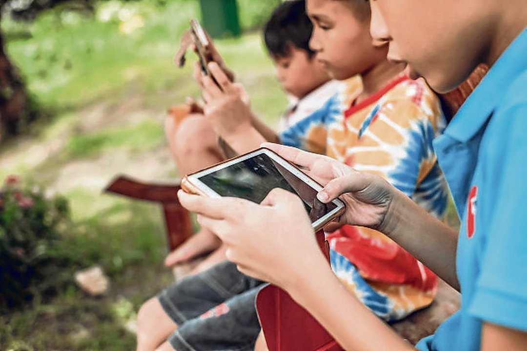 Un grupo de niños con sus dispositivos móviles.