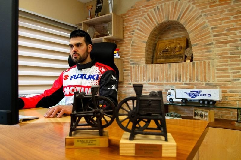El alaricano Javier Pardo, en su oficina de la empresa de transportes familiar junto a sus dos ruedas de afilar, trofeo del Rally de Ourense (ANDRÉS CACHALVITE).