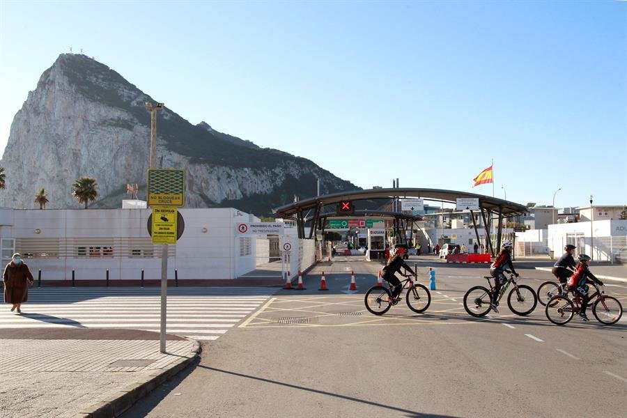 Ciclistas pasan por delante de la frontera con Gibraltar (EFE).