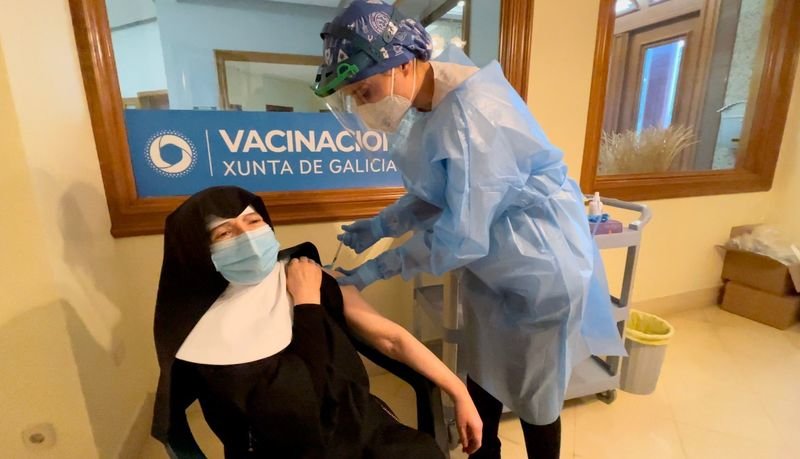 Una sanitaria vacuna a una monja de la residencia San José de Rairo.