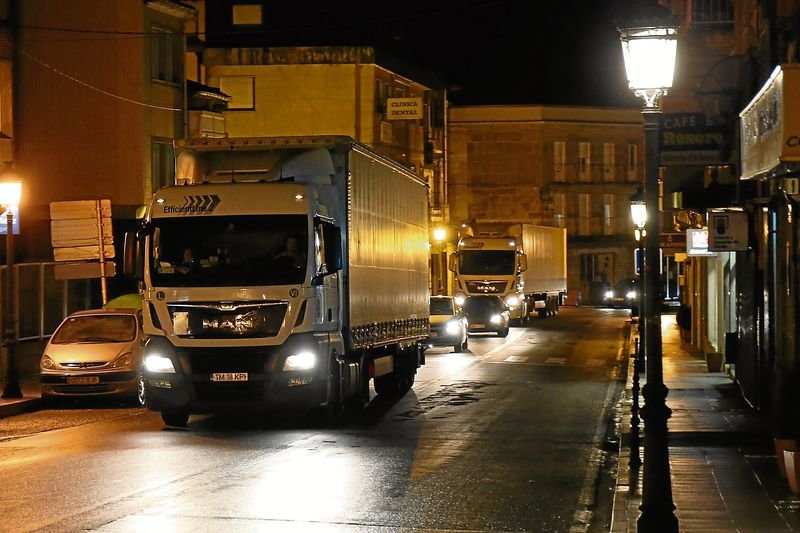 Camiones circulando de noche por el centro de A Cañiza rumbo a la conexión con la A-52.