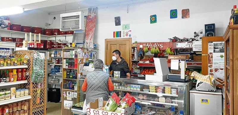 Marcos Pose atiende a una clienta en su pequeña tienda de ultramarinos.
