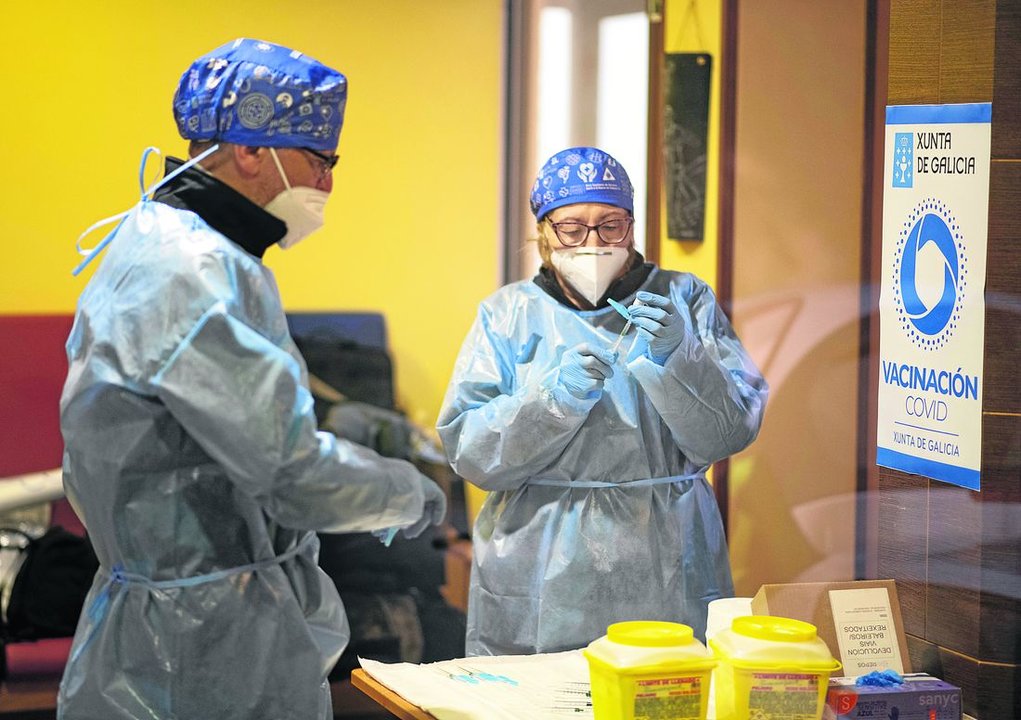 Dos enfermeros preparan las dosis de Pfizer antes de vacunar en la residencia San Marcos, en enero. (Foto: Xesús Fariñas)