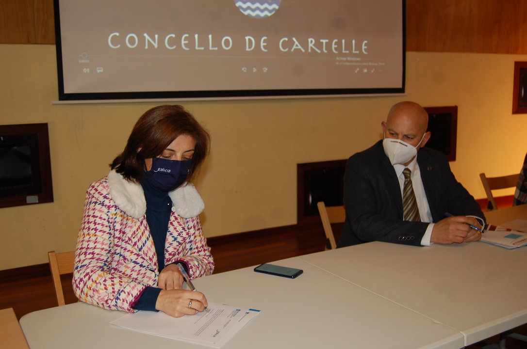 Ángeles Vázquez durante la firma del documento, ante la atenta mirada del alcalde, Jaime Sousa.