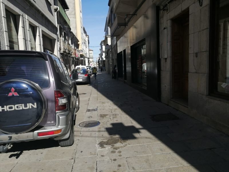 Coches ocupando la mitad de la calle Galicia, mientras estacionan, en el centro de Xinzo de Limia.