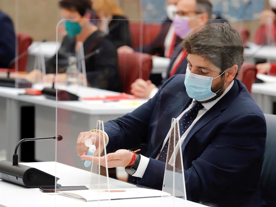 El presidente de la Región de Murcia, Fernando López Miras, usa gel desinfectante, esta mañana, durante el transcurso de la segunda sesión del debate sobre la moción. // EFE