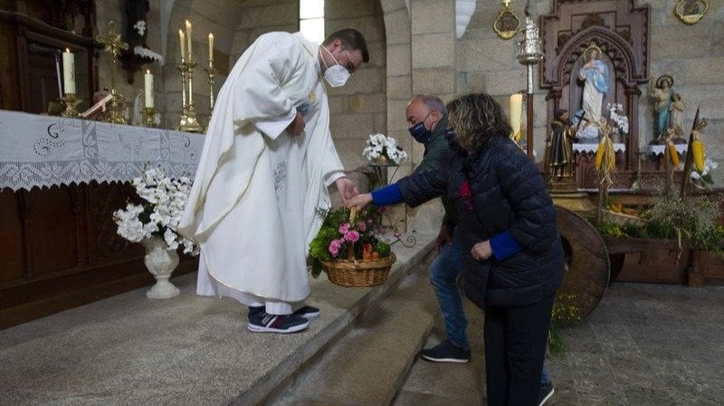 El sacerdote Víctor Bernárdez recoge la ofrenda, ayer en la iglesia de Punxín (MARTIÑO PINAL).