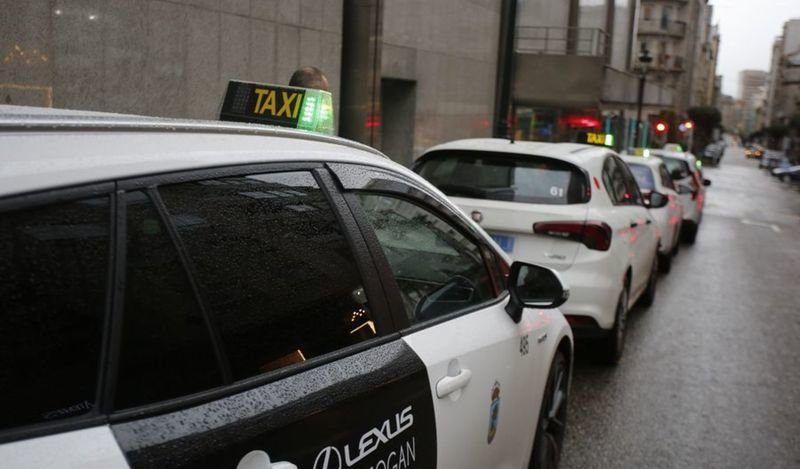 Una parada de taxi en el centro de la ciudad con varios coches aparcados.