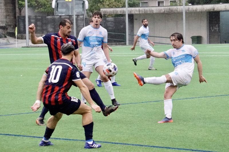 El centrocampista de la UD Ourense, Isi, golpea al balón ante varios jugadores del Estudiantil.