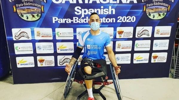Nacho Fernández, integrante del Club Athlos, delante del cartel del "Spanish Padabadminton International".