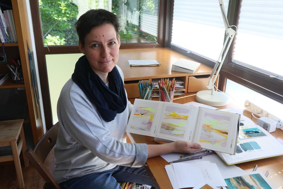 La pintora Isabell Seidel muestra el cuaderno que contiene su #the100dayproject, en Amoeiro. (Foto: José Paz)