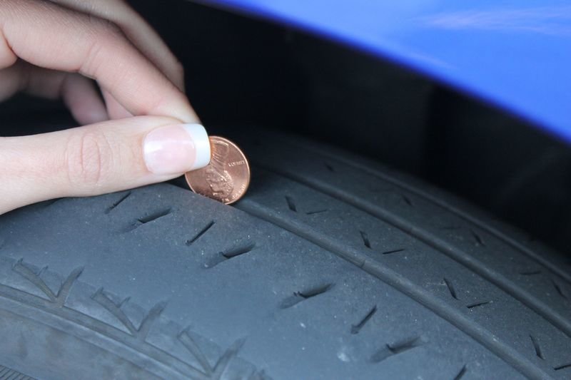 Un usuario comprueba el desgaste de un neumático con una moneda, uno de los métodos habituales.