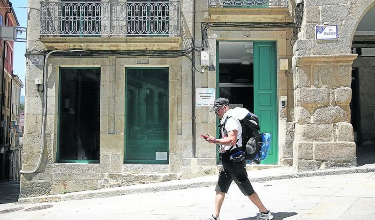 Un peregrino pasea delante del albergue de la ciudad.