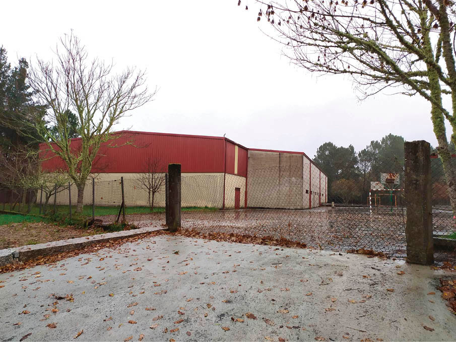 Estado en el que se encuentra el cierre del recinto escolar, con el pabellón al fondo.
