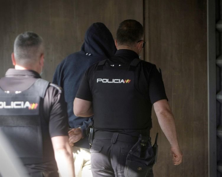 Agentes de la Policía Nacional conducen a uno de los cuatro detenidos por el homicidio de Samuel Luiz este viernes al interior de los juzgados de la Coruña