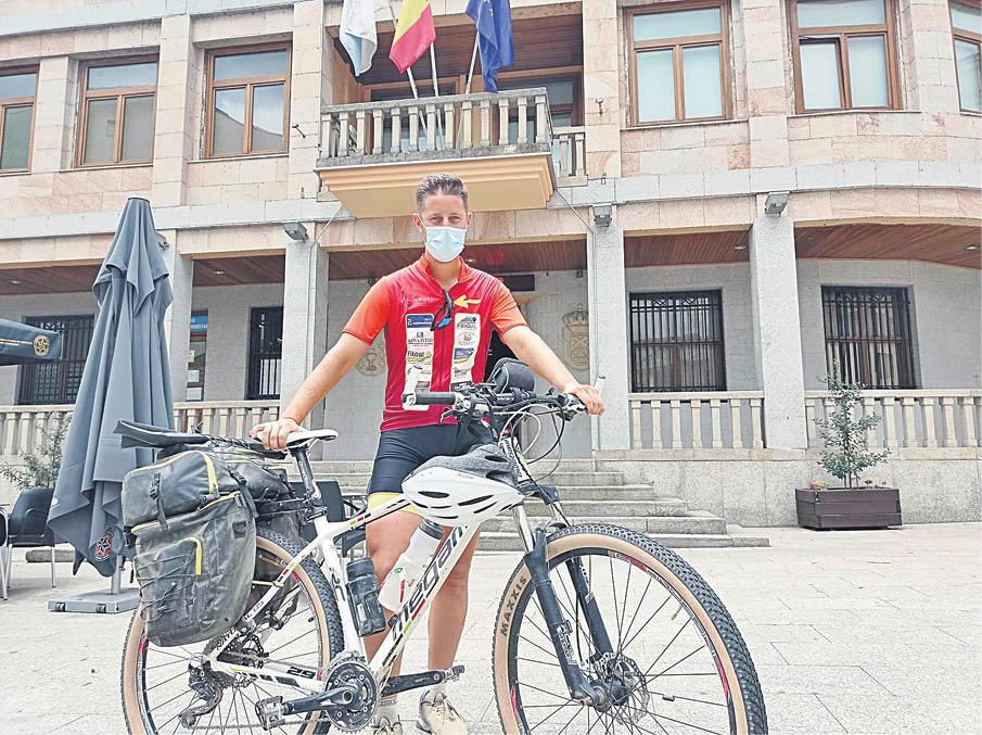 Pedro Hierro posa con su bicicleta frente a la casa consistorial ruesa.